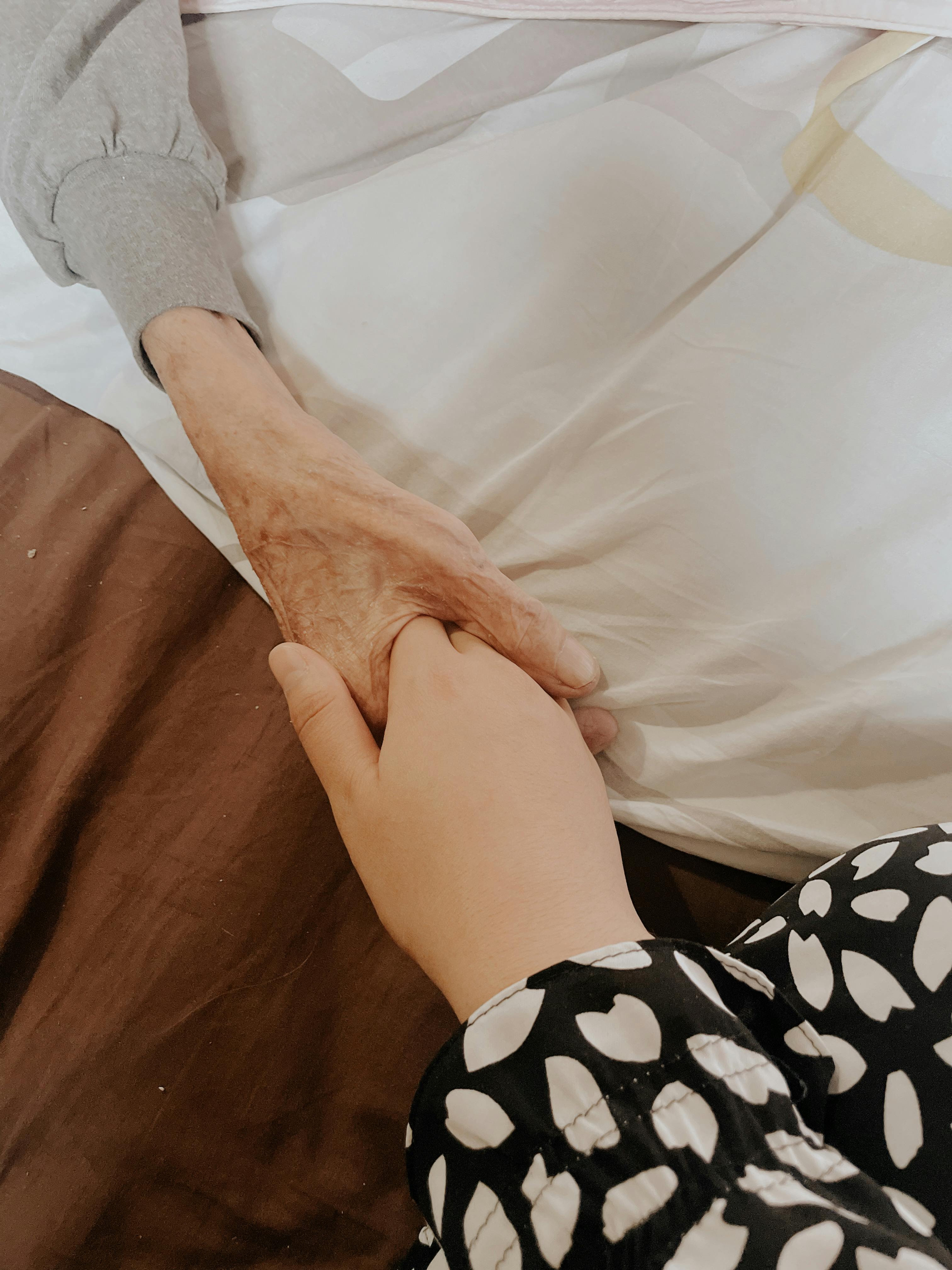 Caregiver holding senior's hand