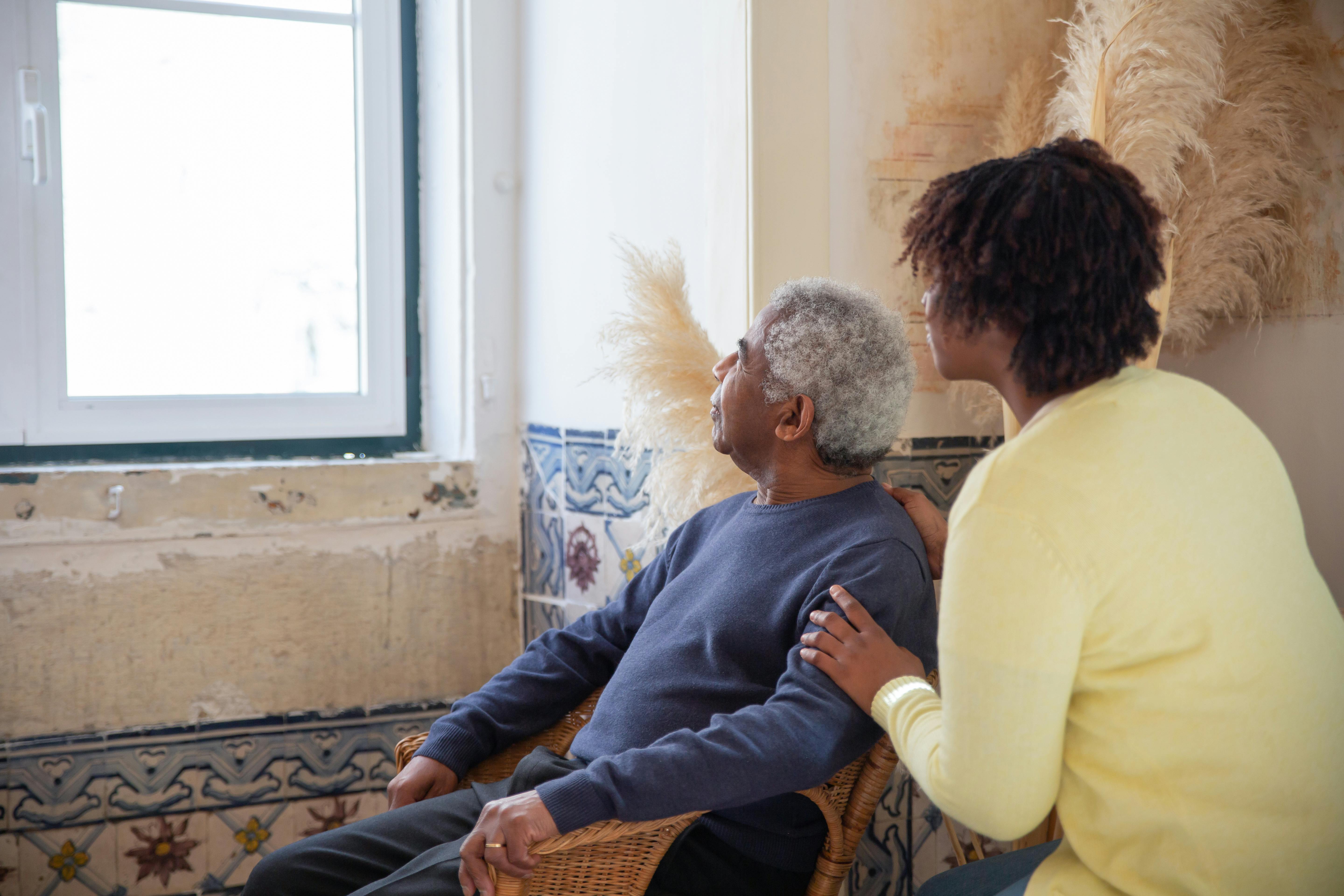 Caregiver and senior looking out window