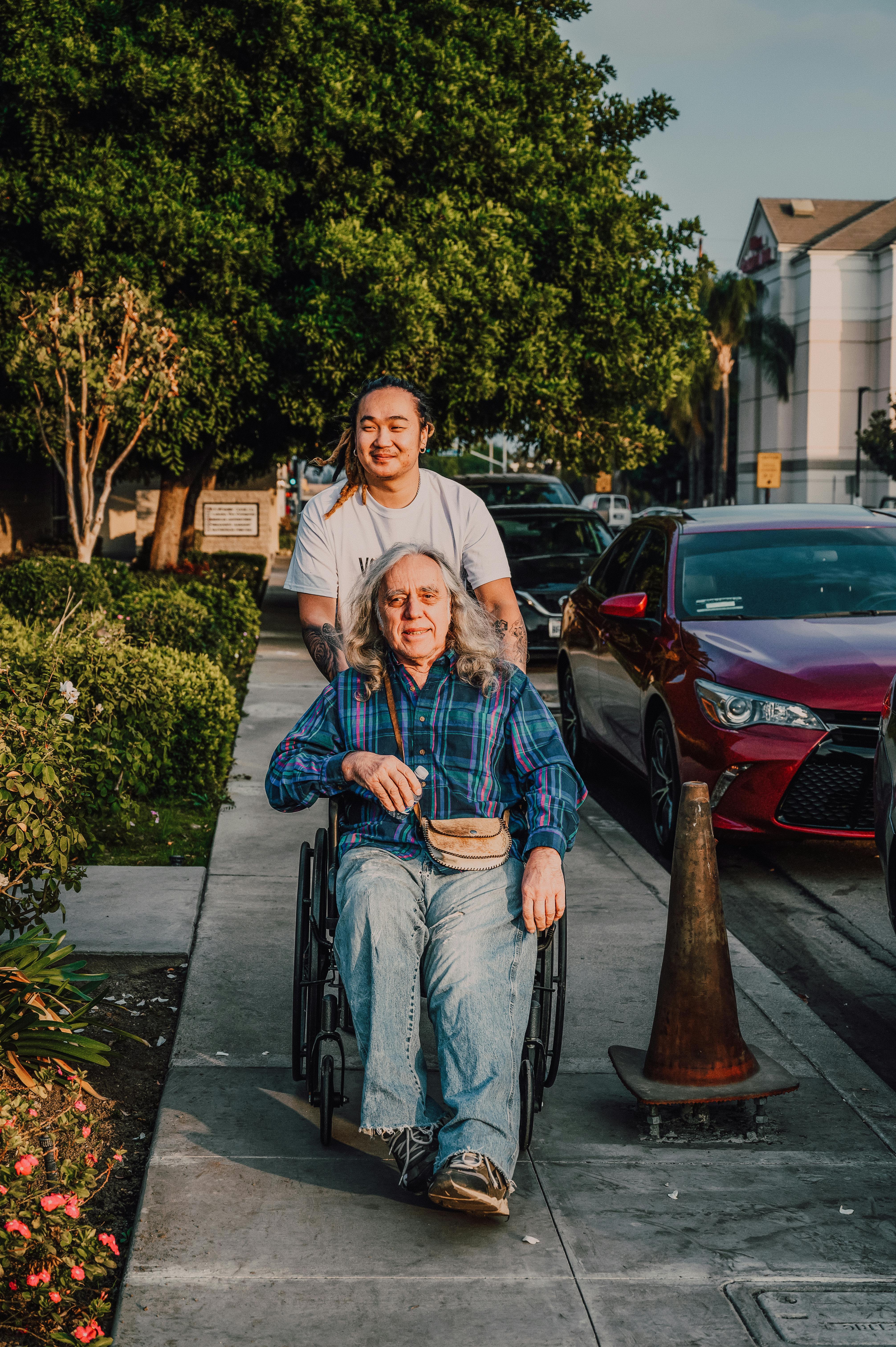 Caregiver pushing senior in wheelchair outdoors